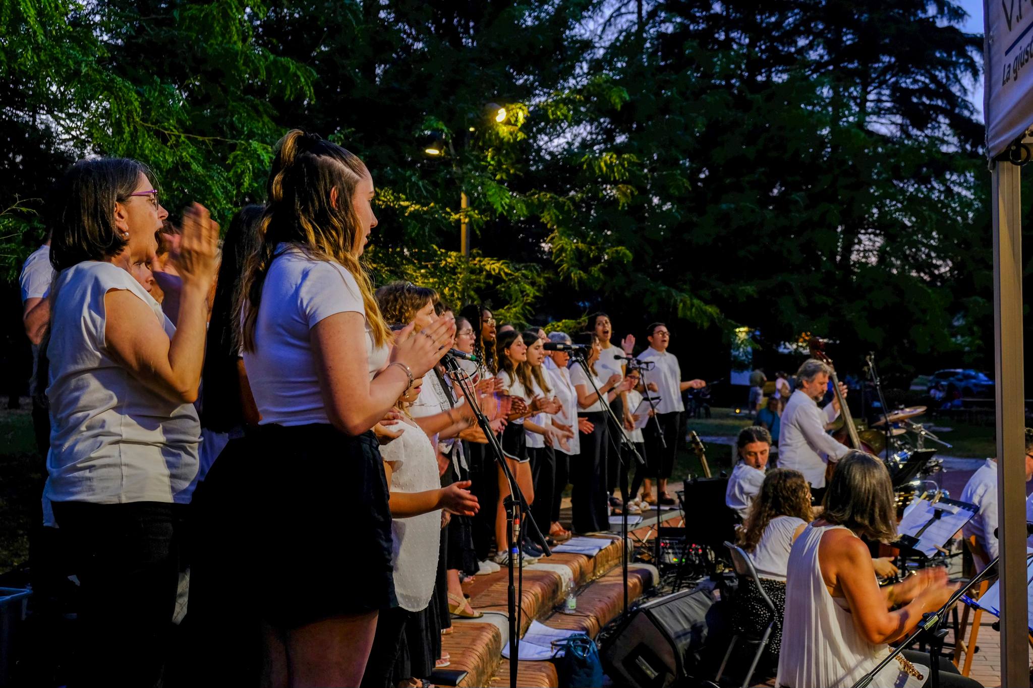Coro DoreMimosa durante un concerto all’aperto con musicisti e cantanti