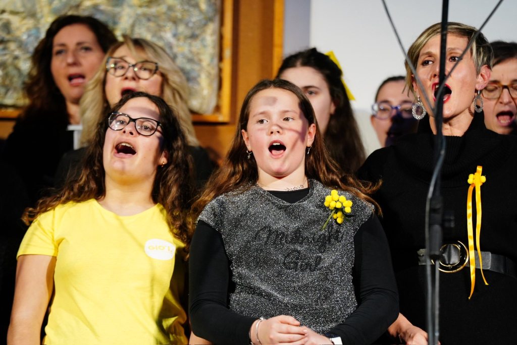 Donne e ragazze del coro DoreMimosa durante un momento di canto collettivo